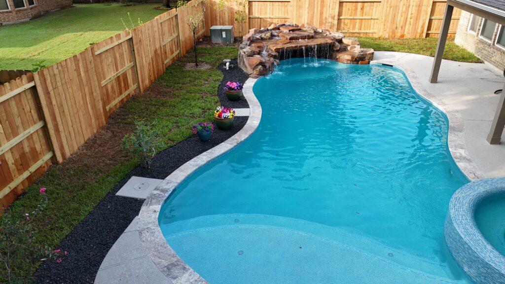 Custom freeform pool with circular spa and rock waterfall in Katy TX — Beach'n Pools